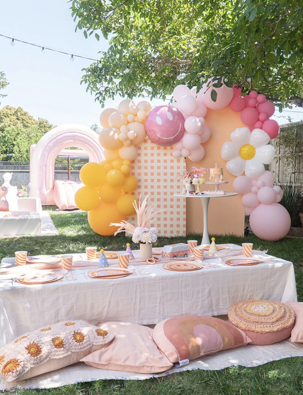 Outdoor pastel party setup with balloon backdrop