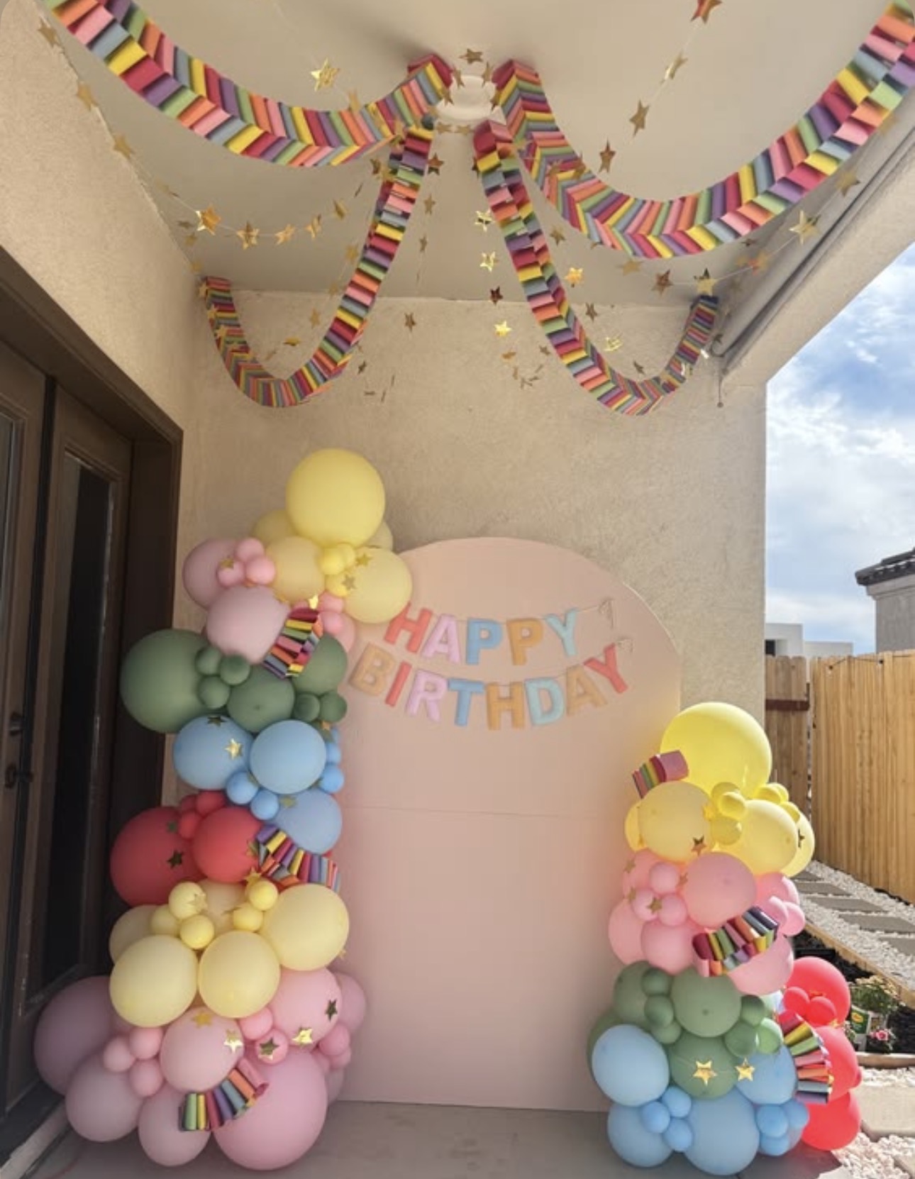 Rainbow balloon towers with pink birthday backdrop