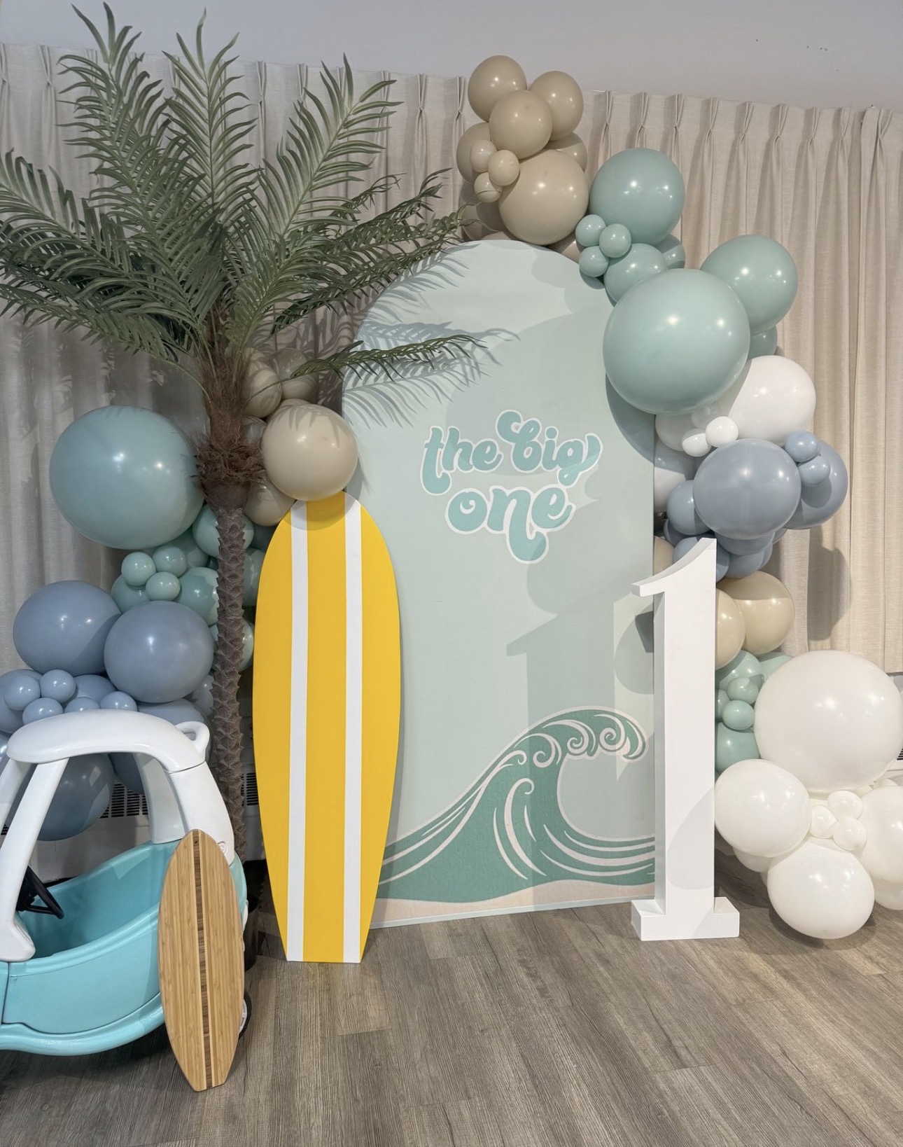 Surf themed first birthday backdrop with balloon styling