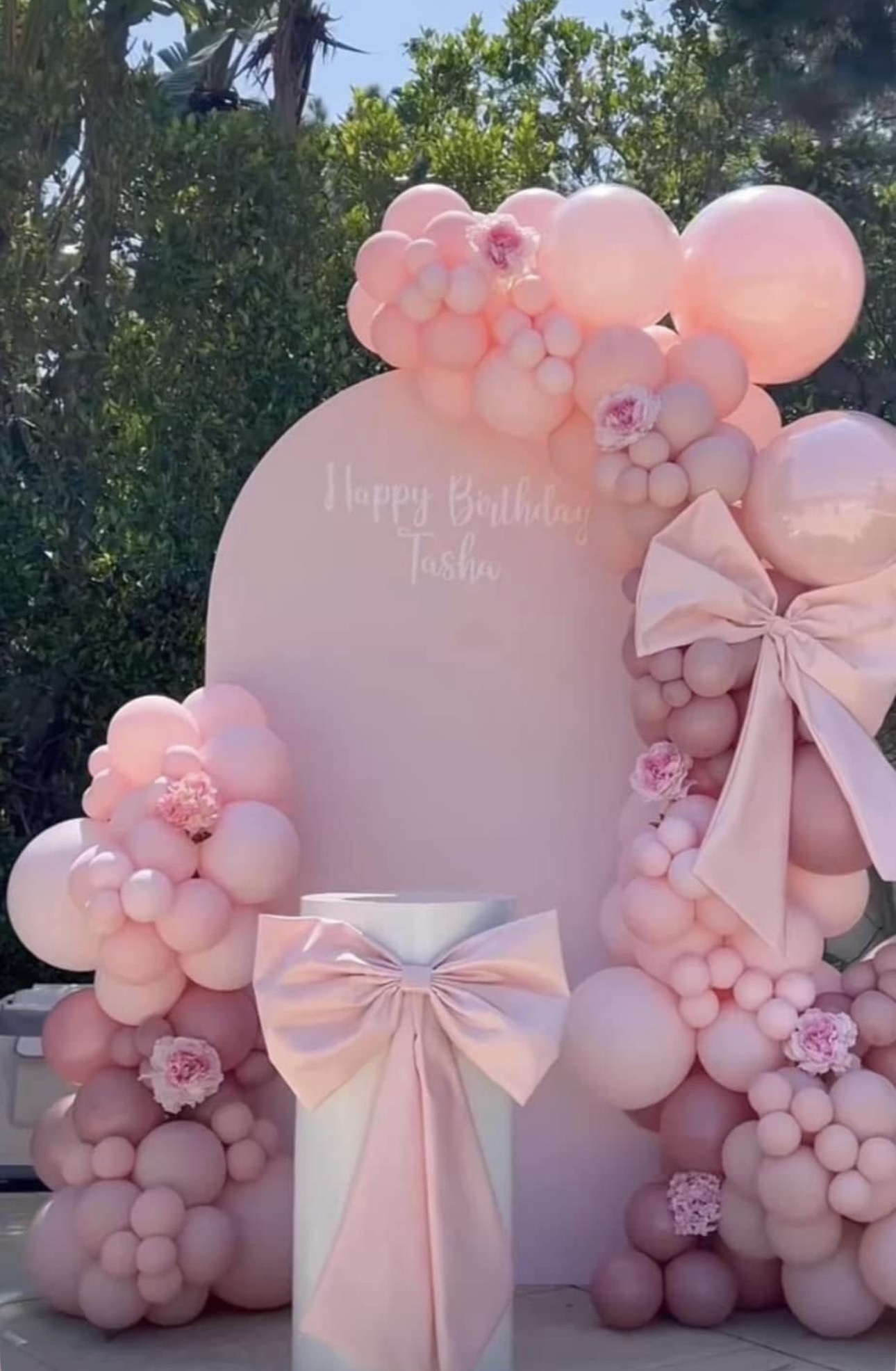Outdoor pink bow backdrop with balloon garland