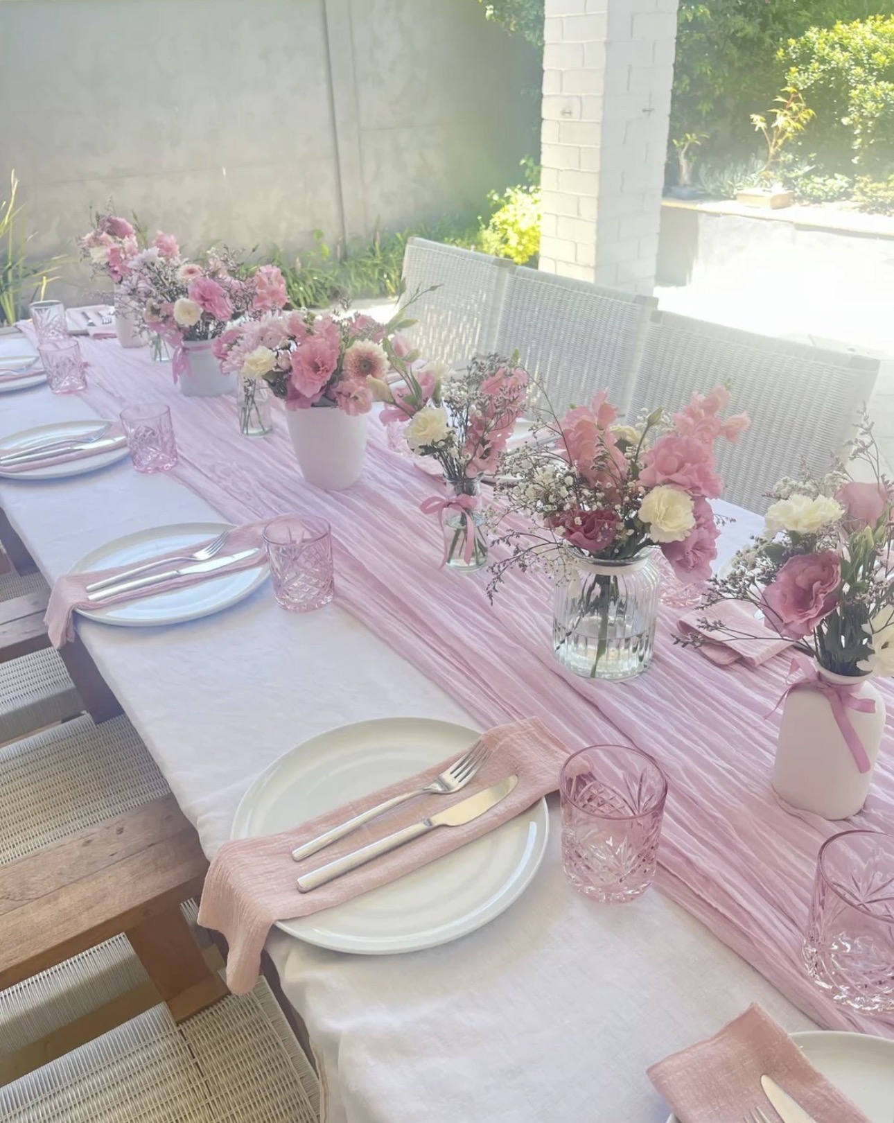 Outdoor pink tablescape with floral centerpieces