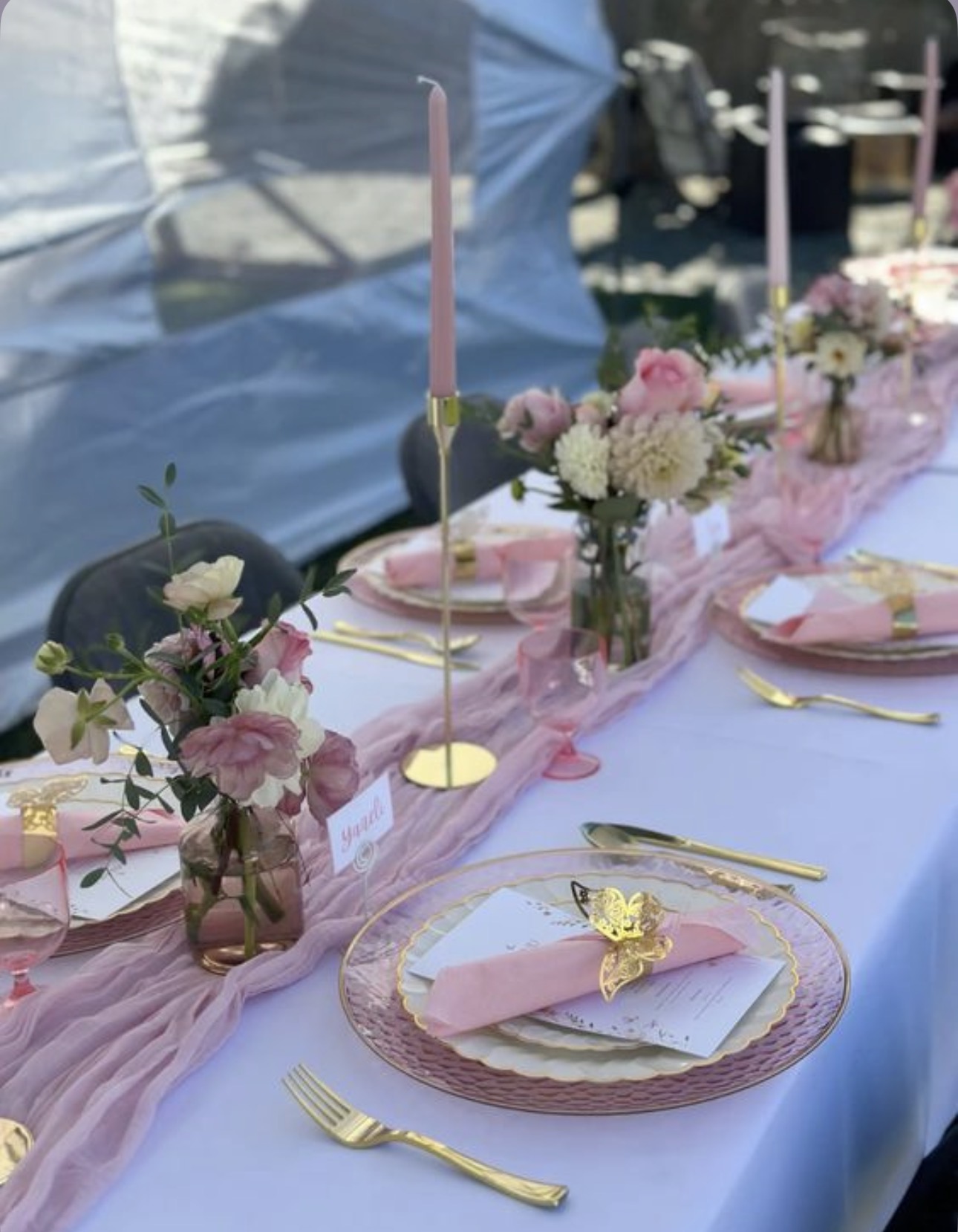 Pink tablescape with floral bud vases and gold accents
