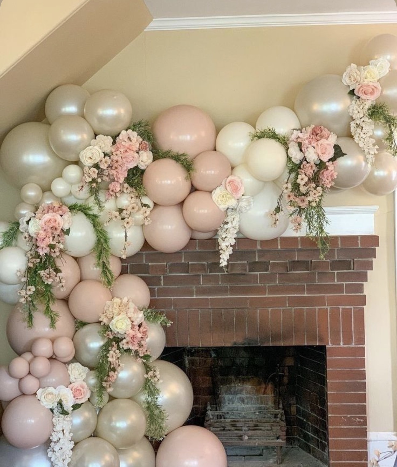 Blush and pearl balloon garland over fireplace