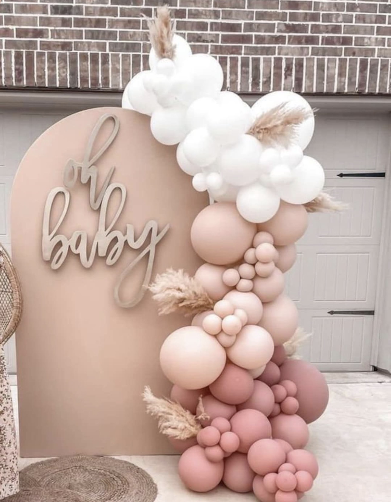 Neutral baby backdrop with pink balloon garland