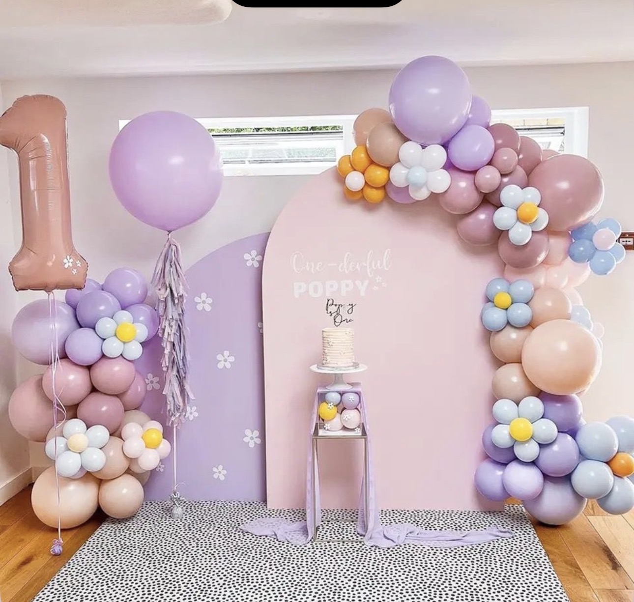Pastel flower balloon backdrop with cake pedestal