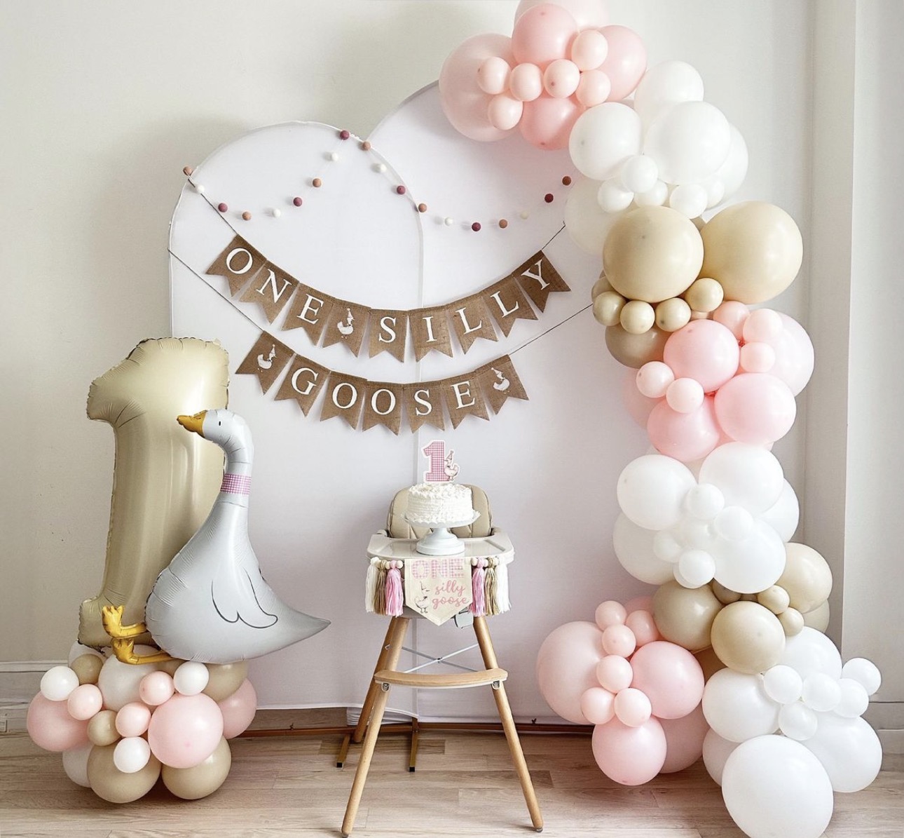 Pink and cream balloon backdrop with goose party accents